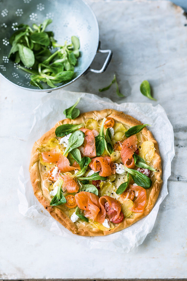 Potato pizza with smoked salmon and lamb's lettuce