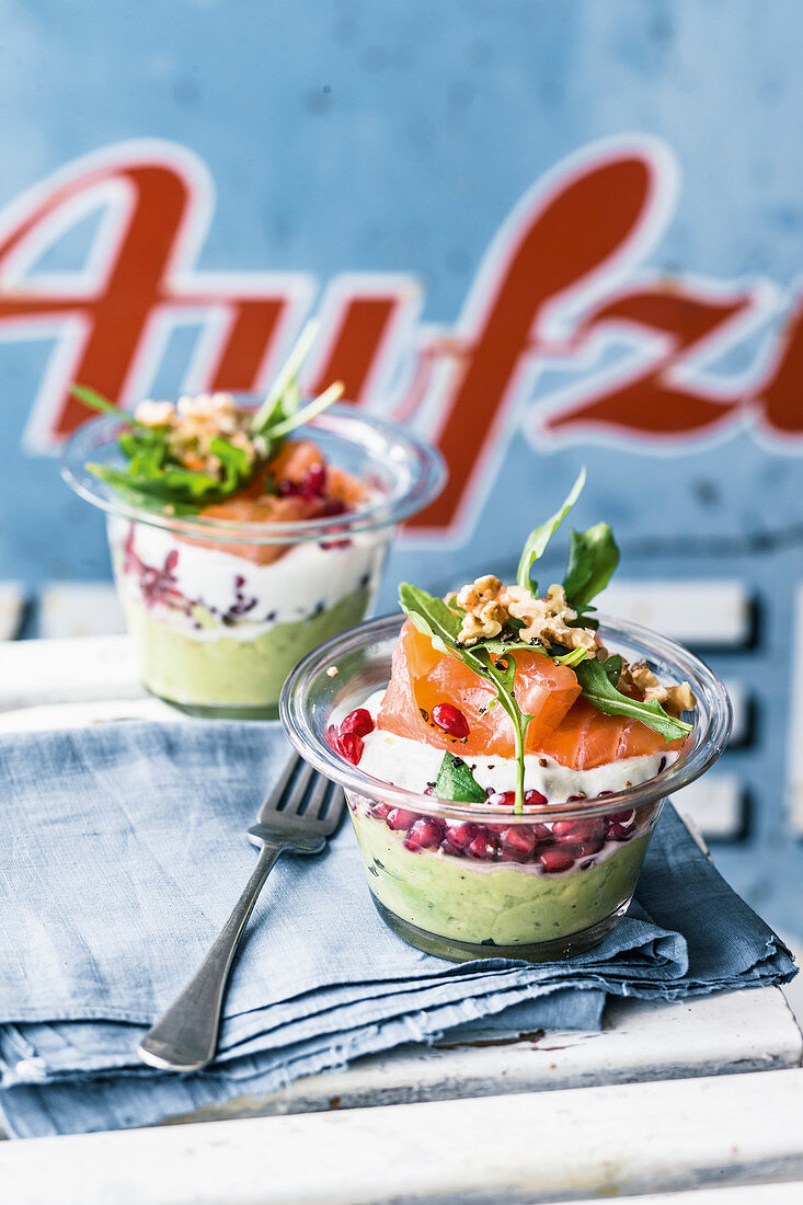 Salmon in glasses with avocado and walnuts