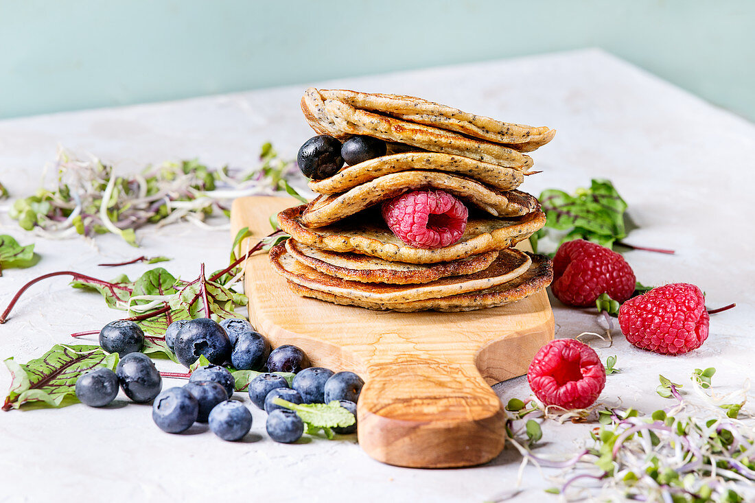 Vegane Kichererbsen-Pancakes mit Beeren auf Brett aus Olivenholz
