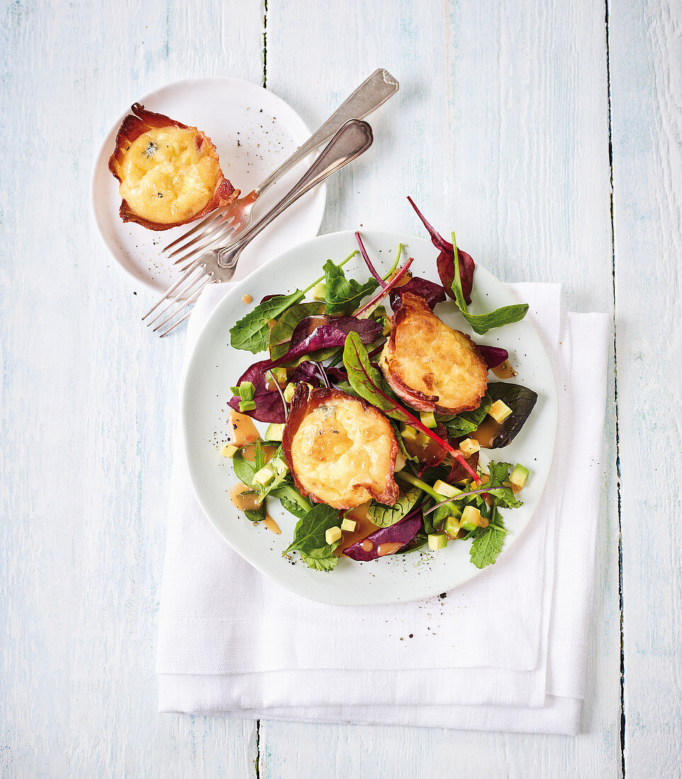 An egg and cheese muffin with a bacon edge and a wild herb salad (low carb)