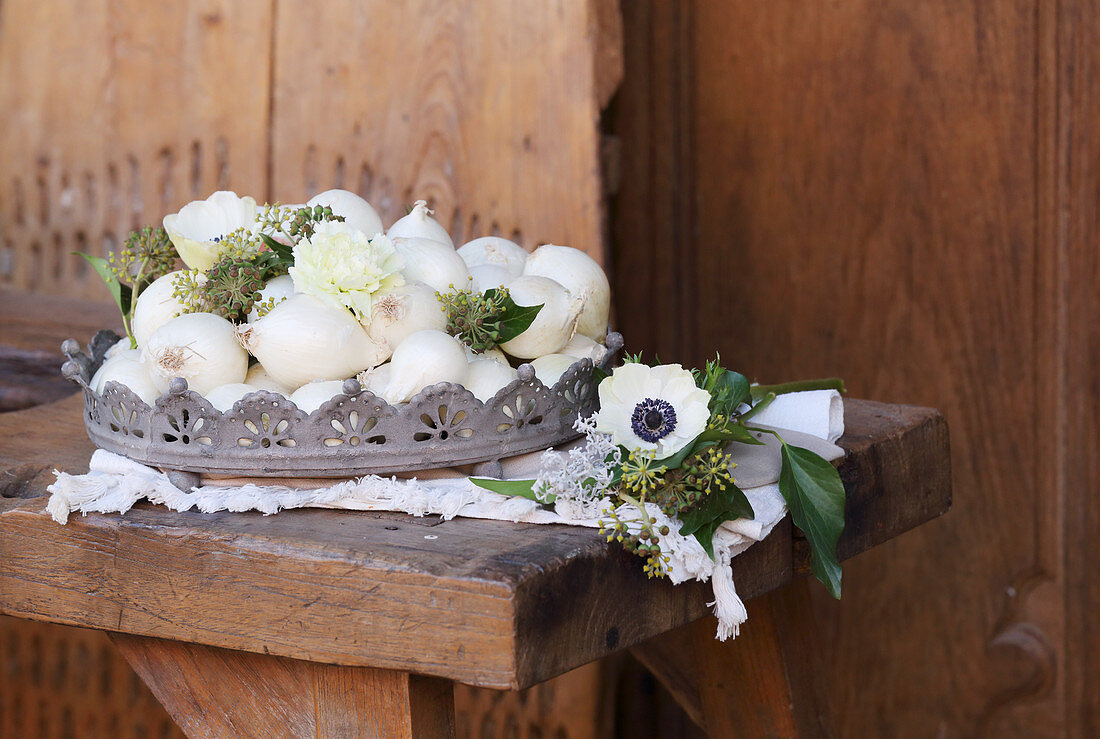 White onions, carnations, anemones and ivy in metal basket