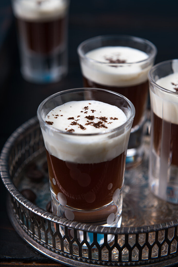 Glasses of coffee schnapps with cream on a tray