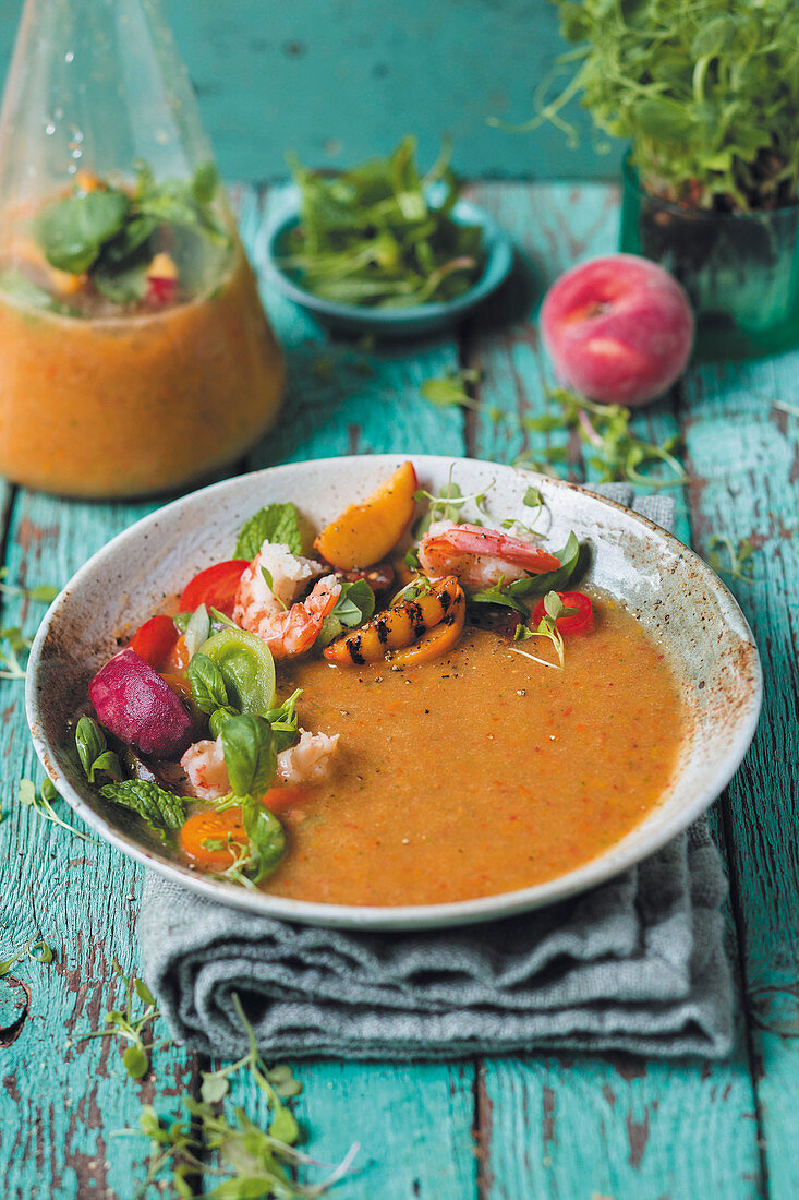 Summery peach and tomato soup with cucumber and paprika