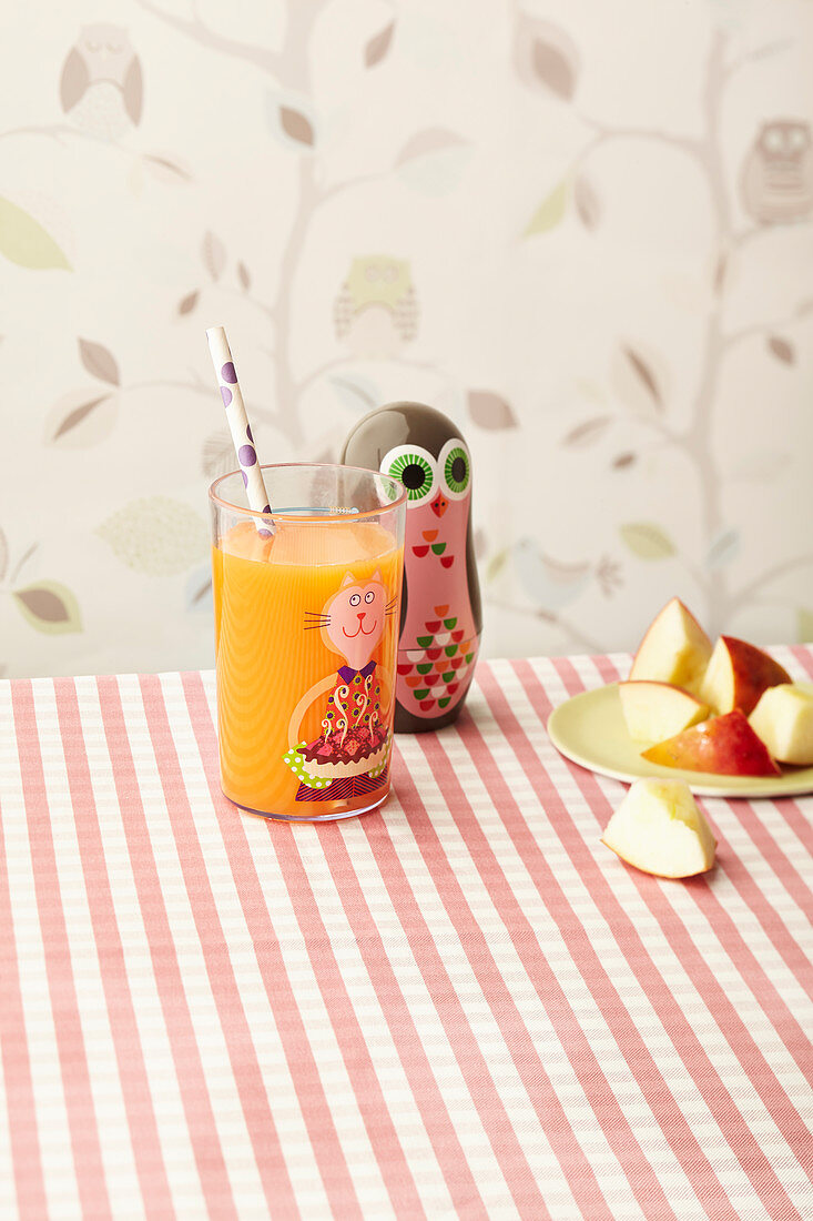 ACE vitamin juice for children in a colourful glass with a straw