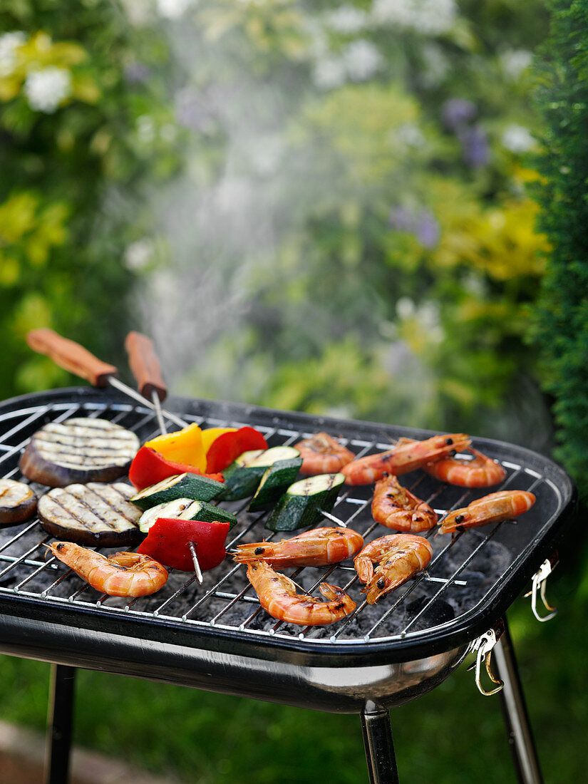Prawns and vegetable kebabs on a grill