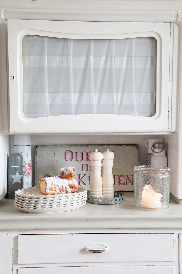 Easter lamb, salt and pepper mills and candle lantern on old white dresser