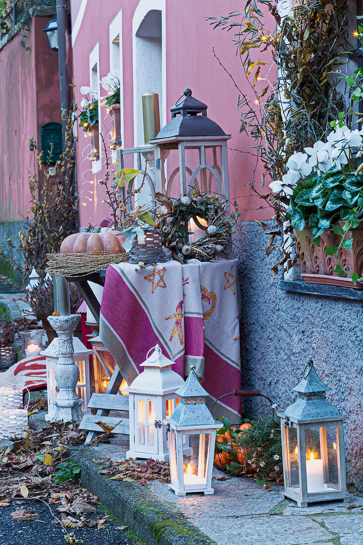 Lanterns with autumn decorations arranged on a house wall