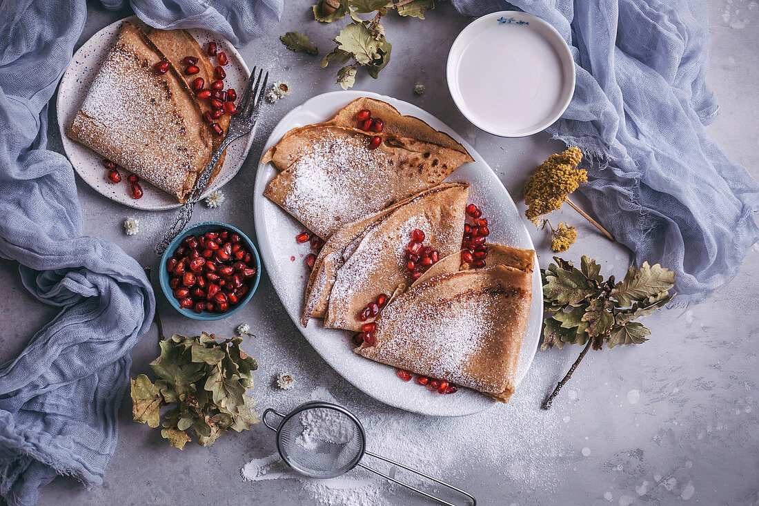 Spelt flour crepes with pomegranate seeds served for breakfast