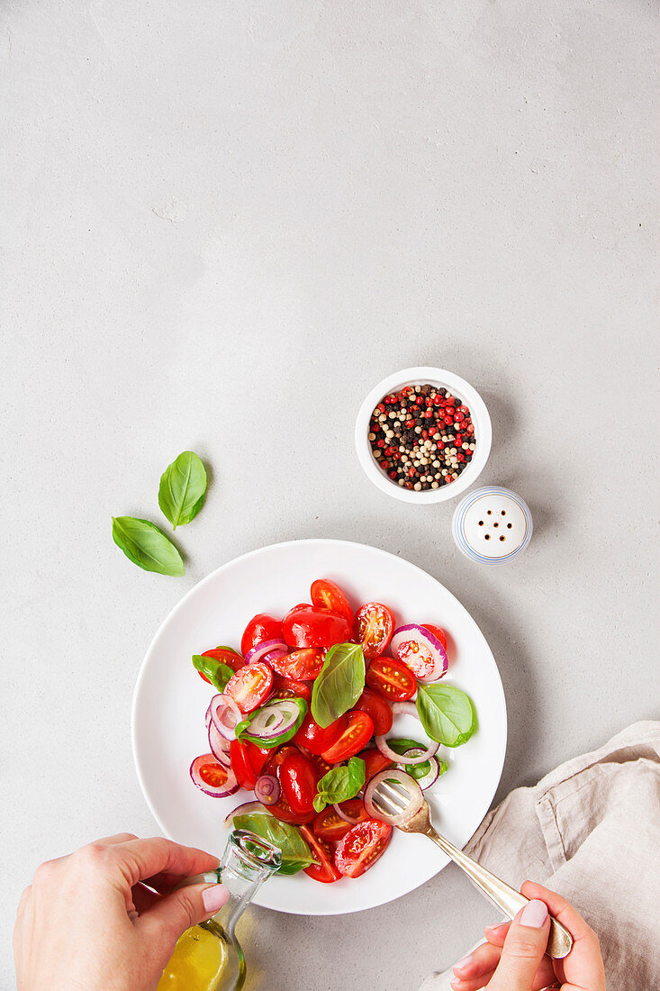 Tomatensalat mit Zwiebeln, Basilikum, Pfeffer und Olivenöl (Aufsicht)