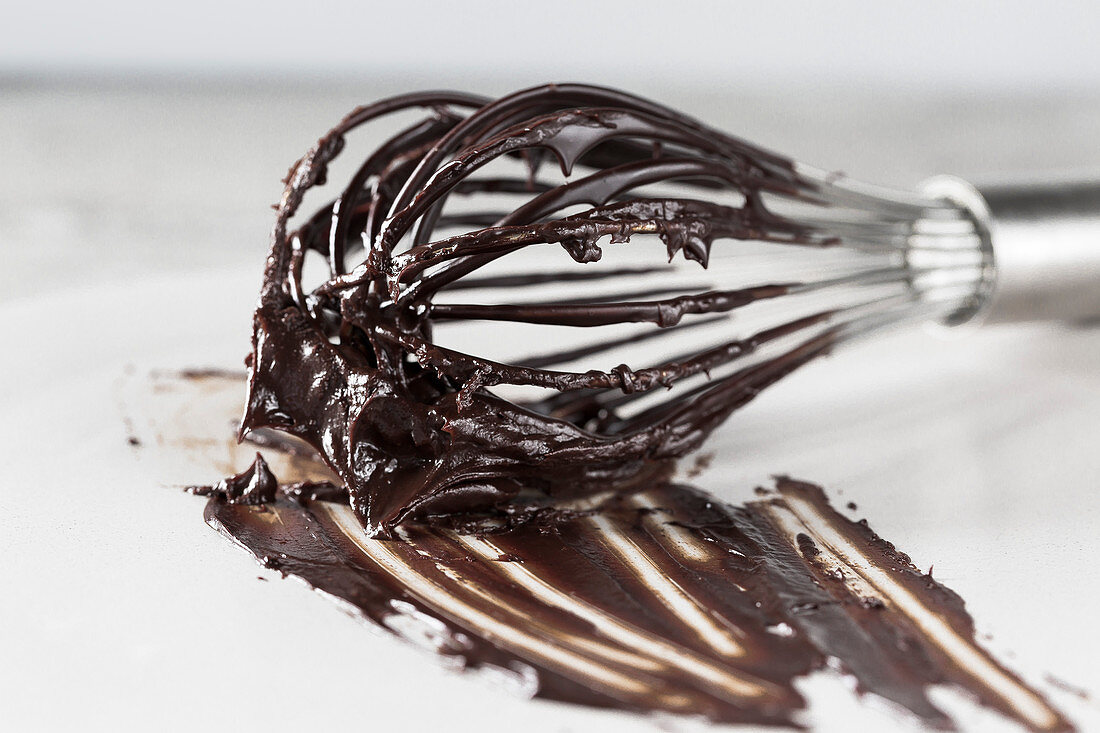 A whisk with chocolate ganache (close up)