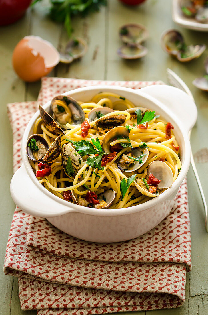 Spaghetti with clams, dried tomatoes, spicy salami and parsley