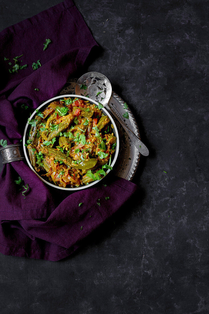 Indian vegetable curry in a bowl on a dark background (top view)
