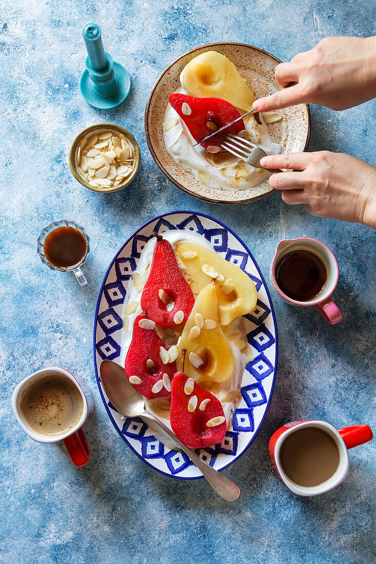 Poached pears served with greek yogurt, maple syrup and almond flakes