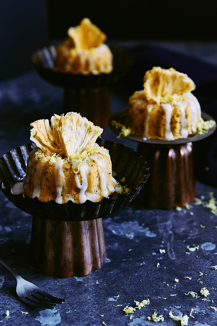 Mini lemon and poppy seed bunt cakes with lemon drizzle icing and dehydrated pineapple