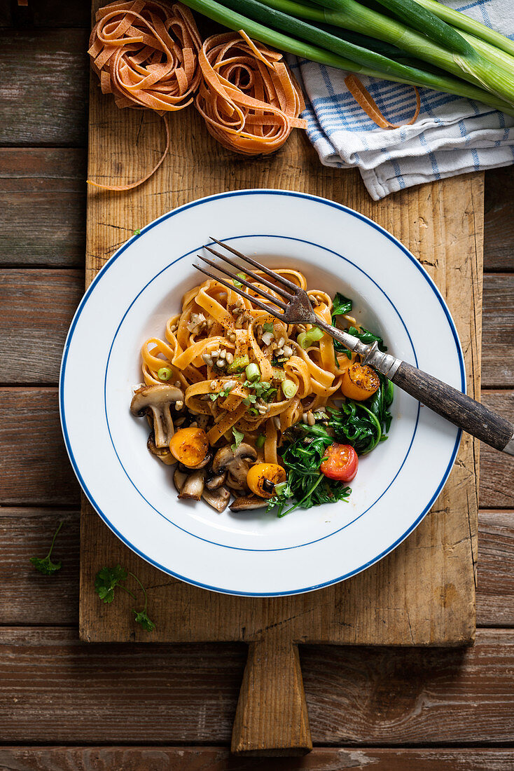 Tomato tagliatelle with arugula, mushrooms, tomatoes, spring onions and toasted sunflower seeds (vegan)