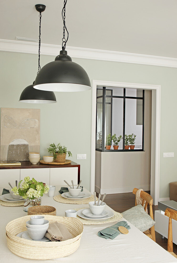 Table set in natural shades in dining room with pale green wall