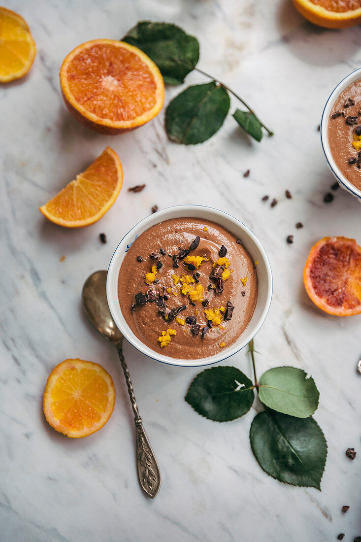 Chocolate orange pudding in serving bowls on white marble table