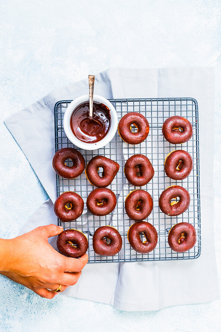Selbstgemachte Mini-Donuts mit Schokoladenglasur auf Abkühlgitter