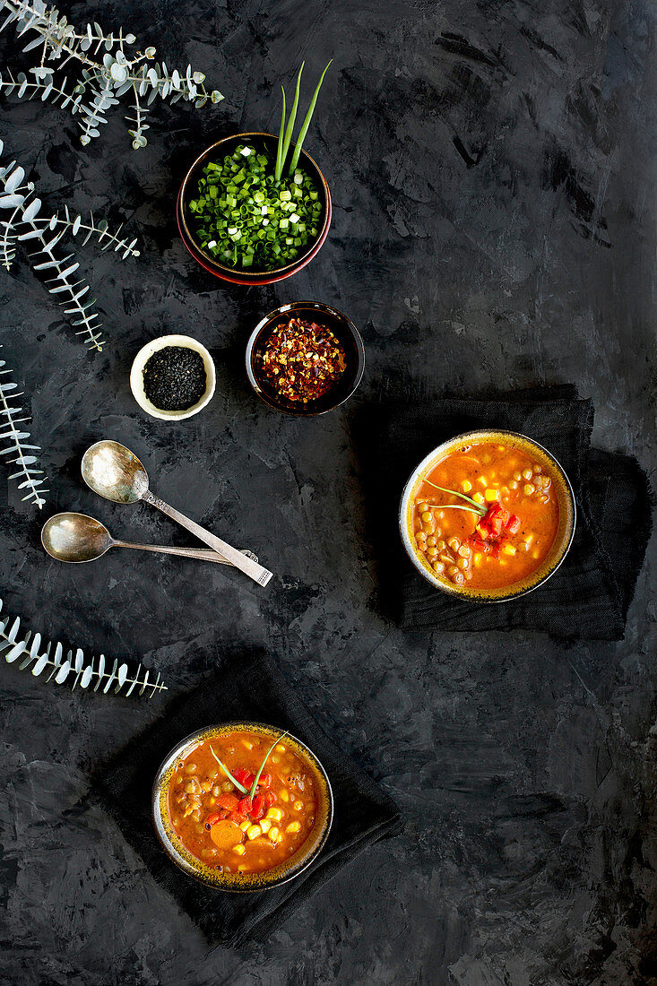 Bowls of Sesame Lentil Soup topped with roasted red peppers and chives