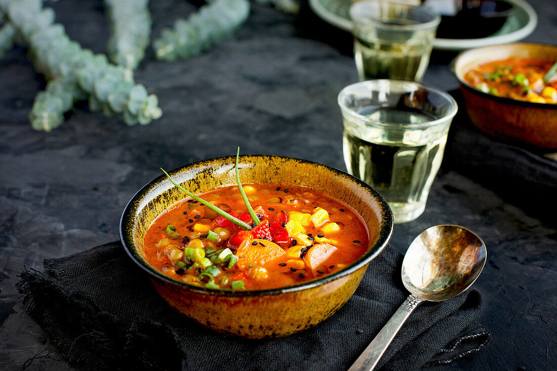 Bowls of Sesame Lentil Soup topped with roasted red peppers and chives