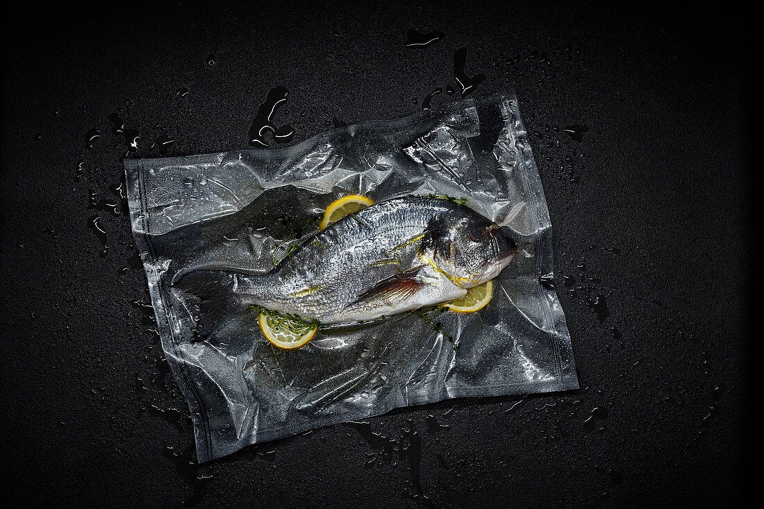 Seabream with lemon slices in a sous vide bag