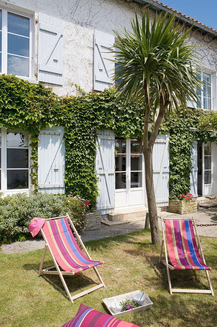 Colourful deckchairs in garden of French country house