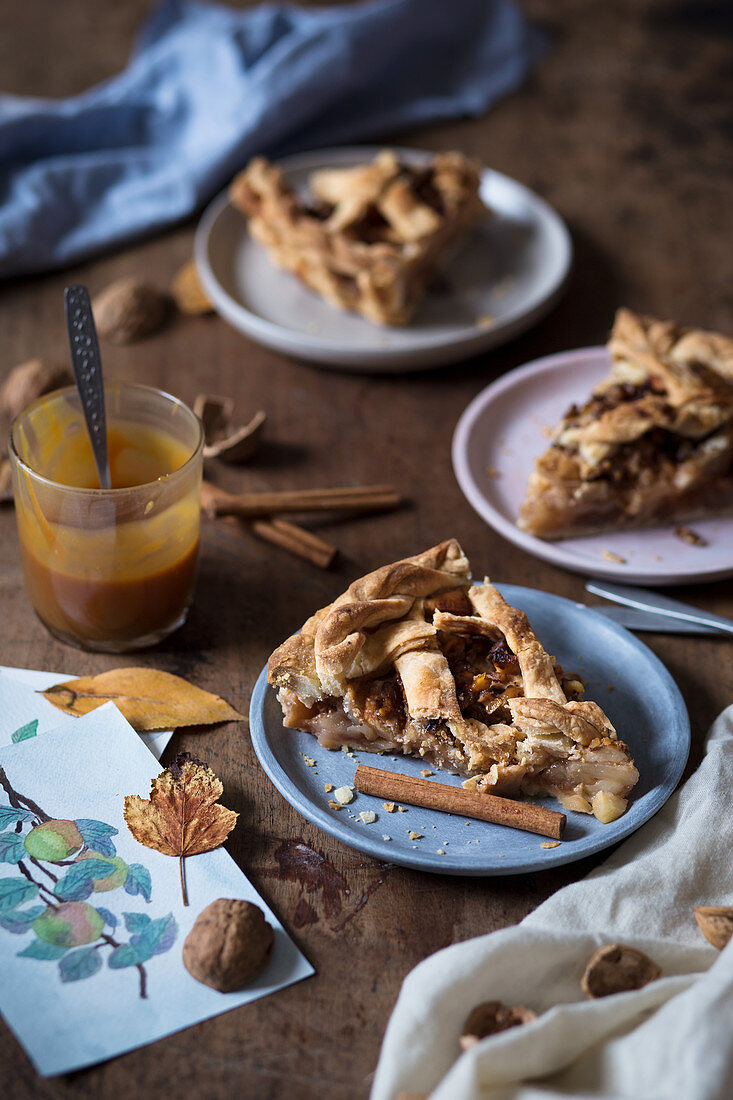 Slices of a rustic apple pie with walnuts and caramel sauce