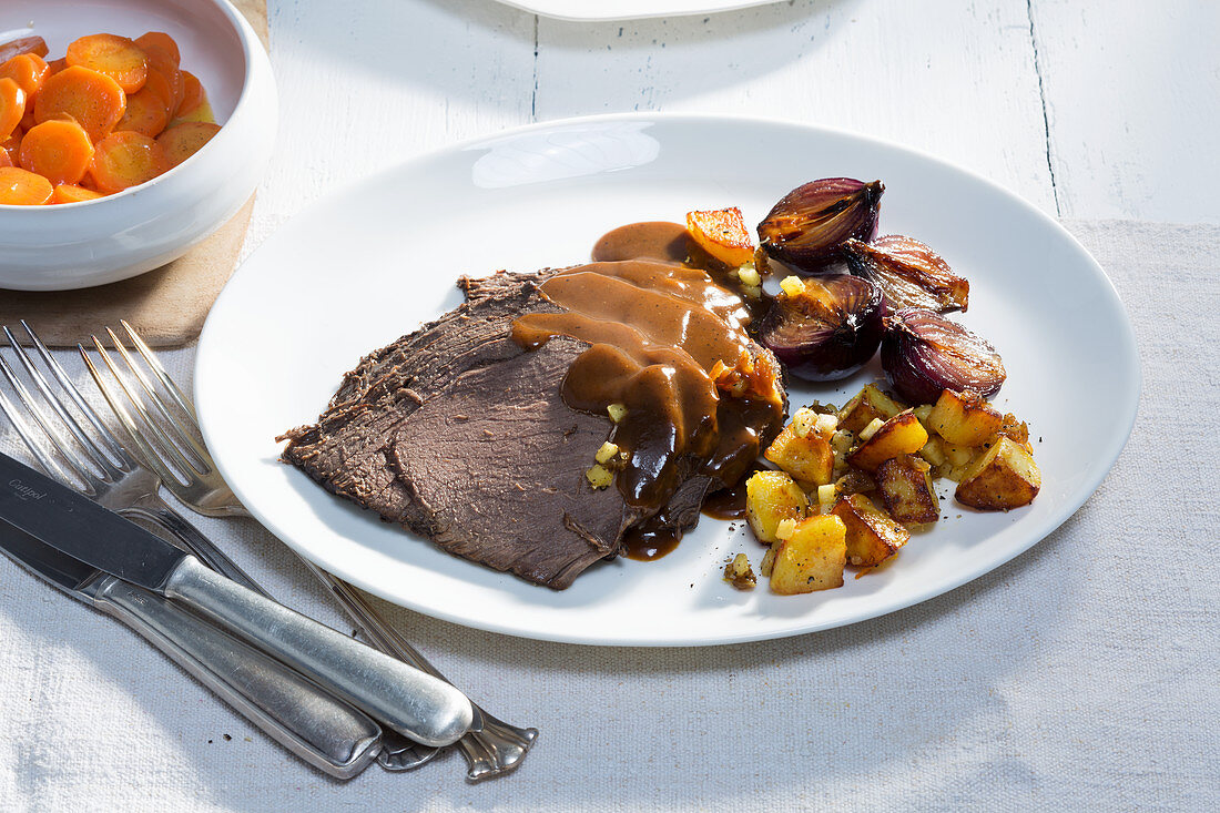 Horse shoulder Sauerbraten (marinated pot roast) with fried potatoes and apples