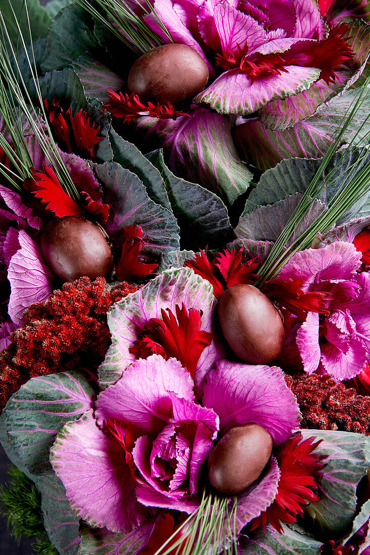 An arrangement of pink shades made from cabbage, plums and flowers (full frame)