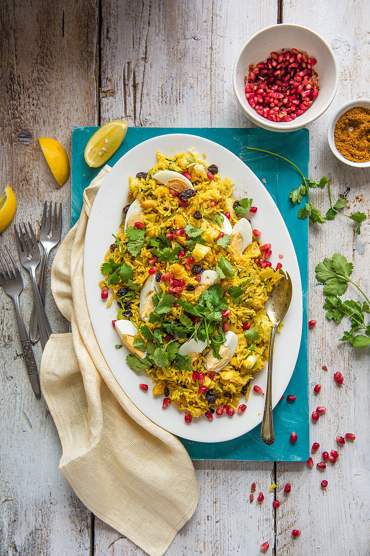 Kedgeree mit geräuchertem Fisch, Ei, Rosinen, Koriander und Granatapfelkernen