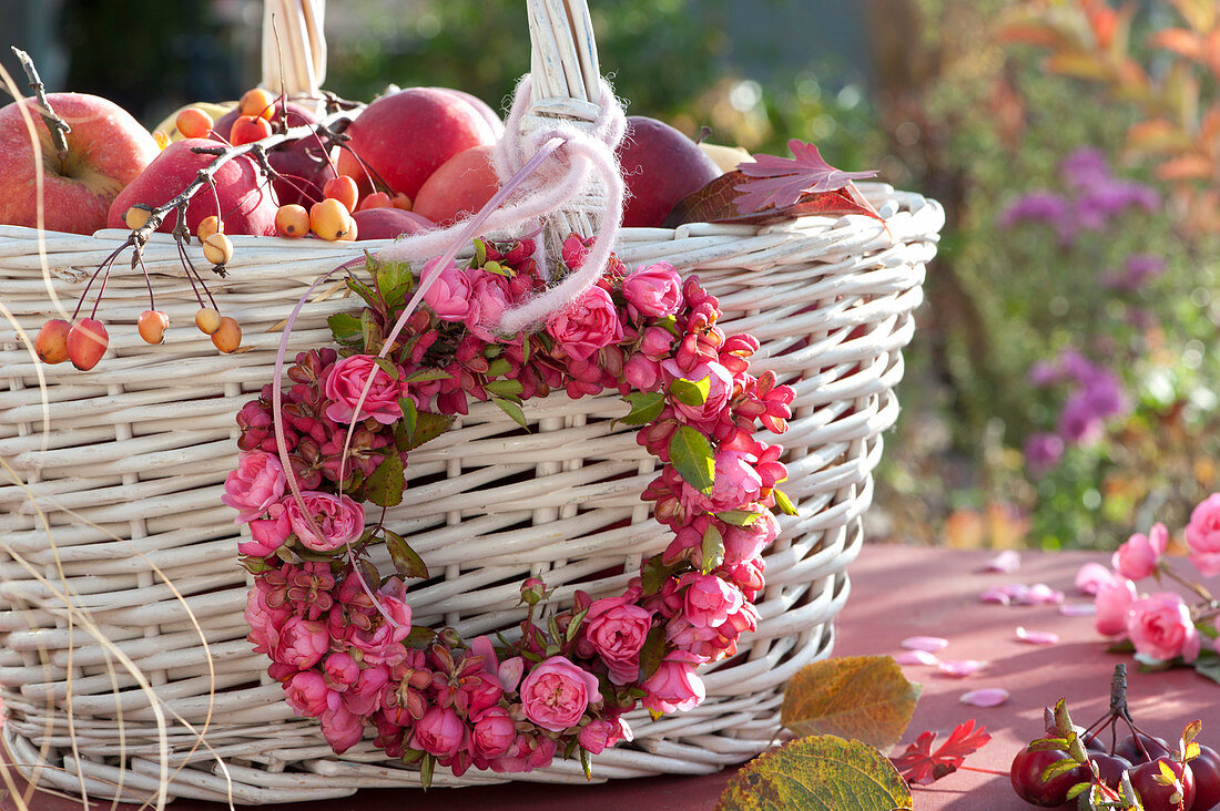 Pinker Herbst-Kranz aus Rosen und Pfaffenhütchen an Korb