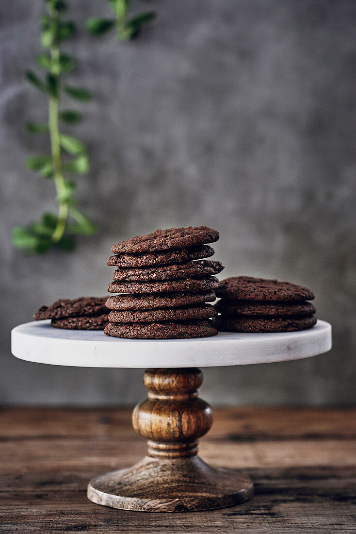 A stack of chocolate biscuits on a cake stand