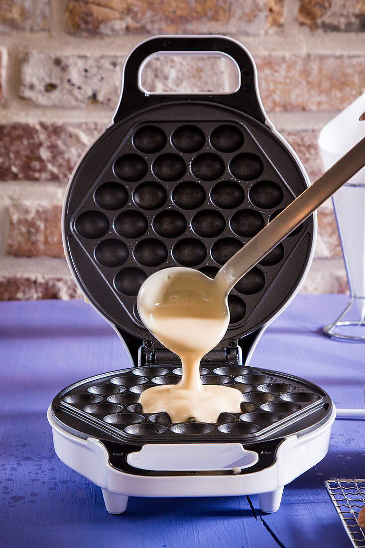 Waffle batter being poured onto a waffle iron