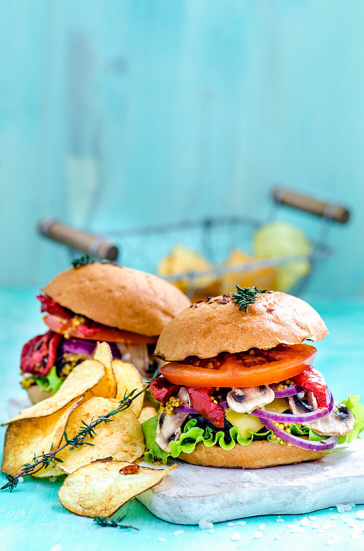 Burger und Kartoffelchips auf hellblauem Hintergrund