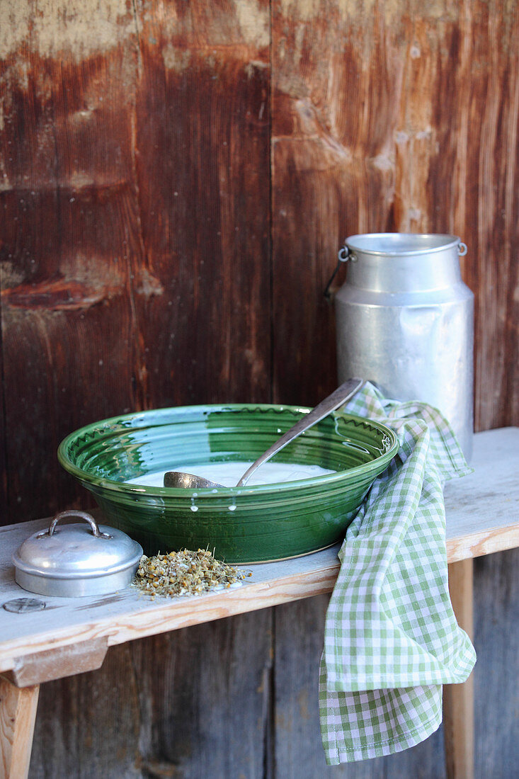 Ingredients for homemade hand lotion with sheep's milk and dried chamomile flowers