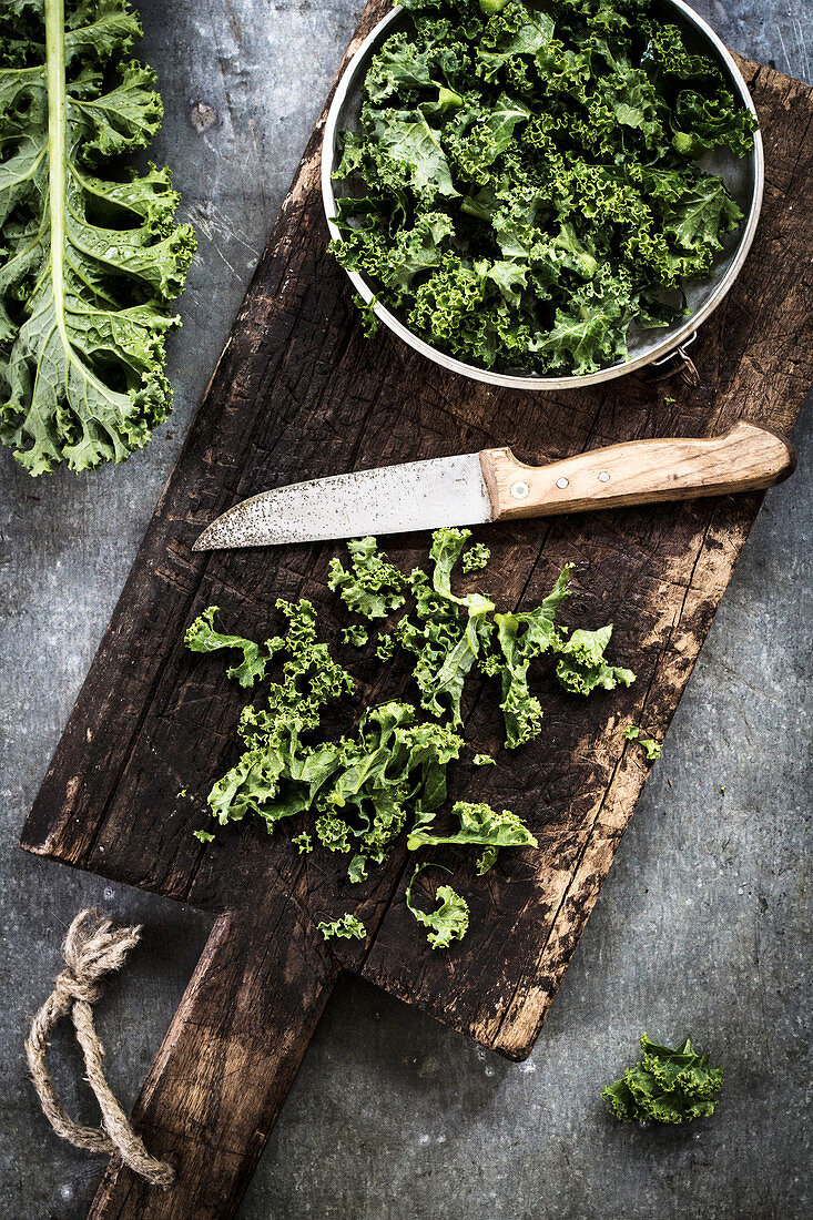 Kale on an old chopping board with a knife