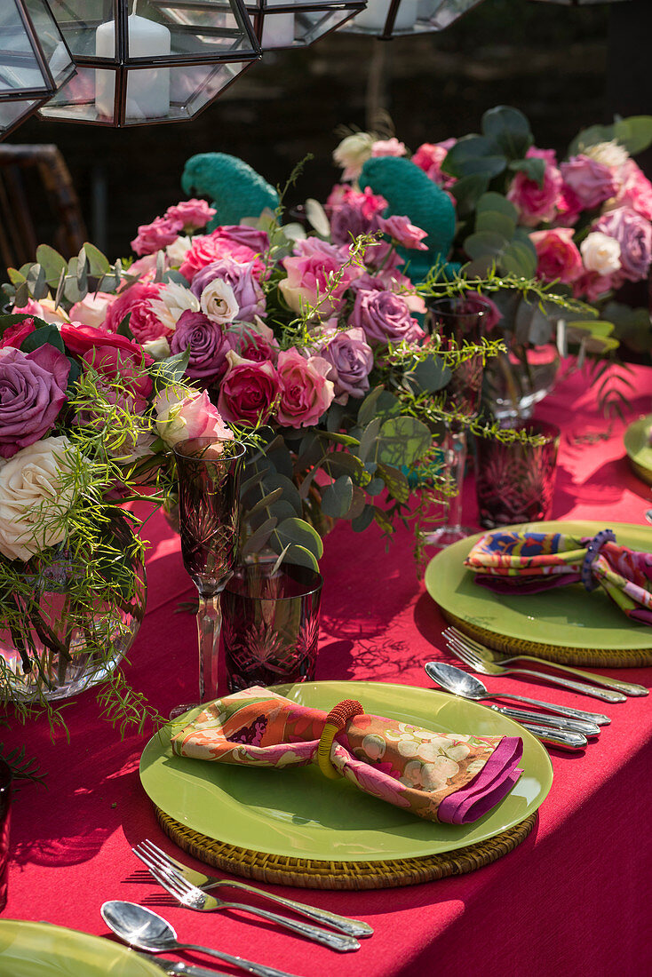 Blumensträuße als Deko auf gedecktem Tisch mit grünen Tellern