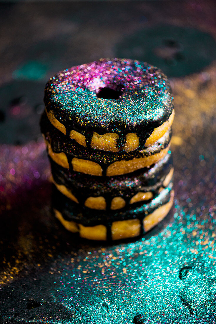 Donuts with a chocolate glaze and glitter, stacked