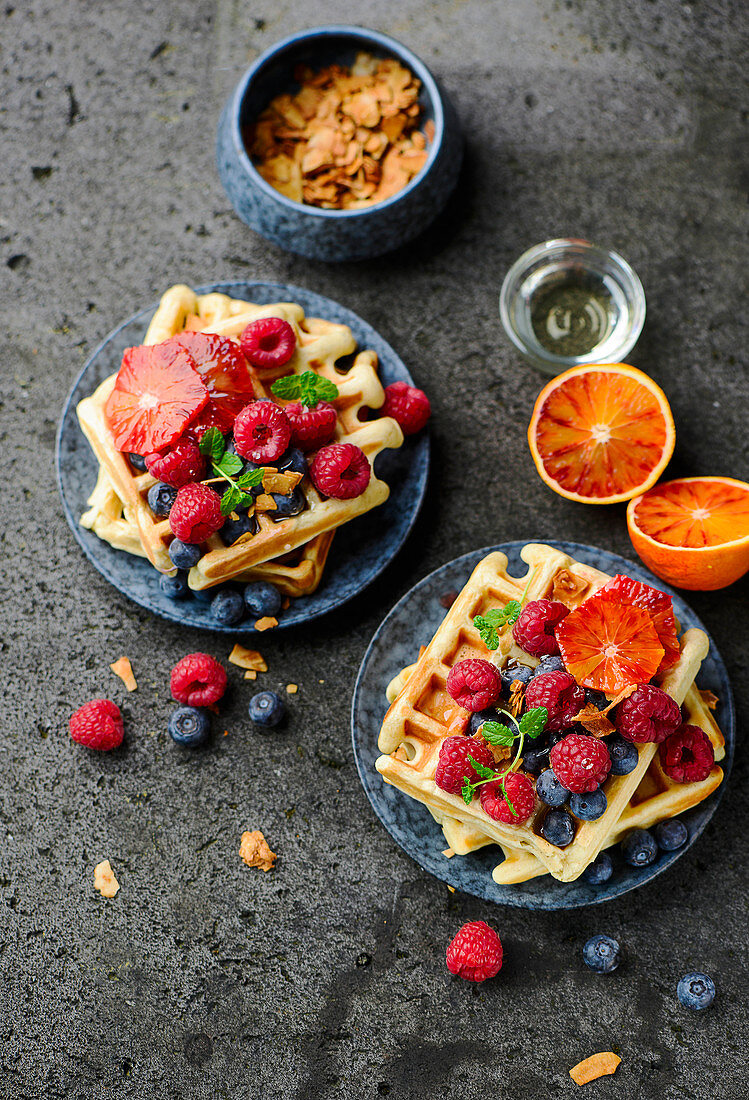 Banana waffles with fresh berries, blood oranges and coconut chips