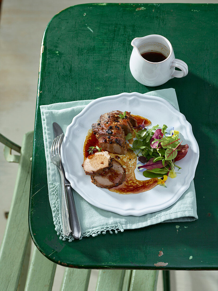 Schweinefilet mit schwarzem Pfeffer auf Gartentisch