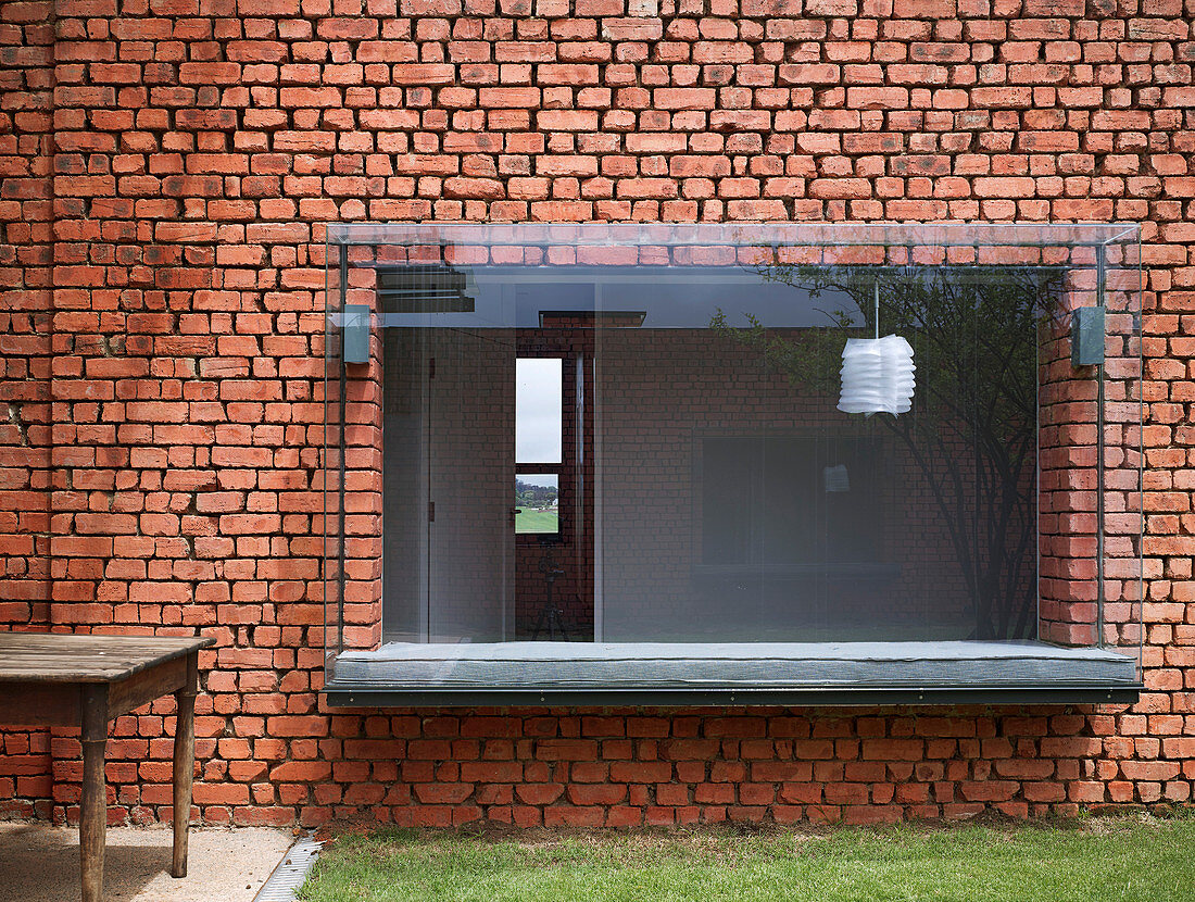 Window seat in modern bay window in old brick wall