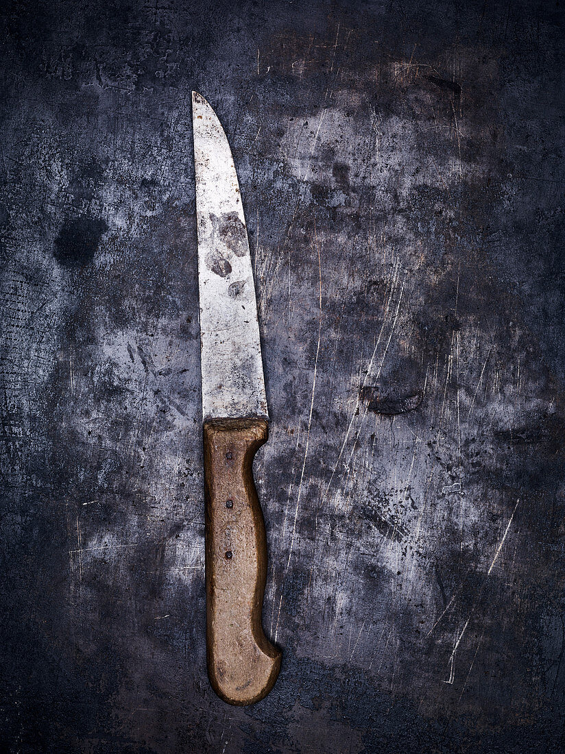 A vintage kitchen knife on a gray metal background (top view)