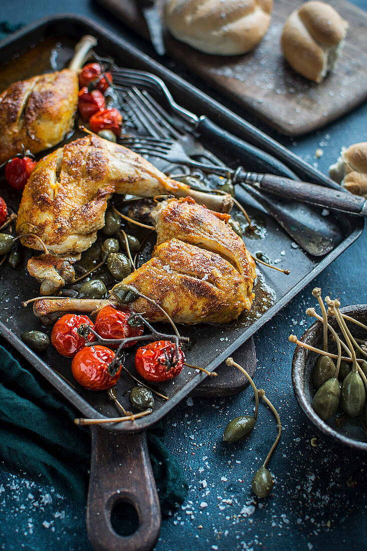 Gebratene Hähnchenschenkel mit Riesenkapern und Kirschtomaten