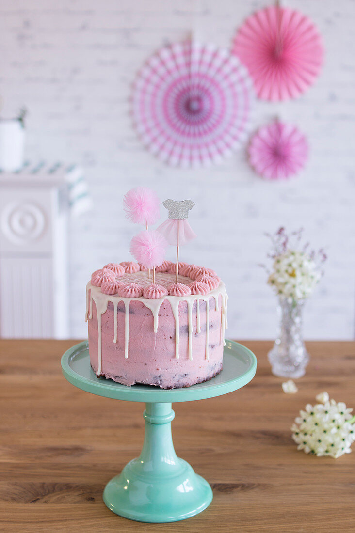Pink birthday cake with party decorations