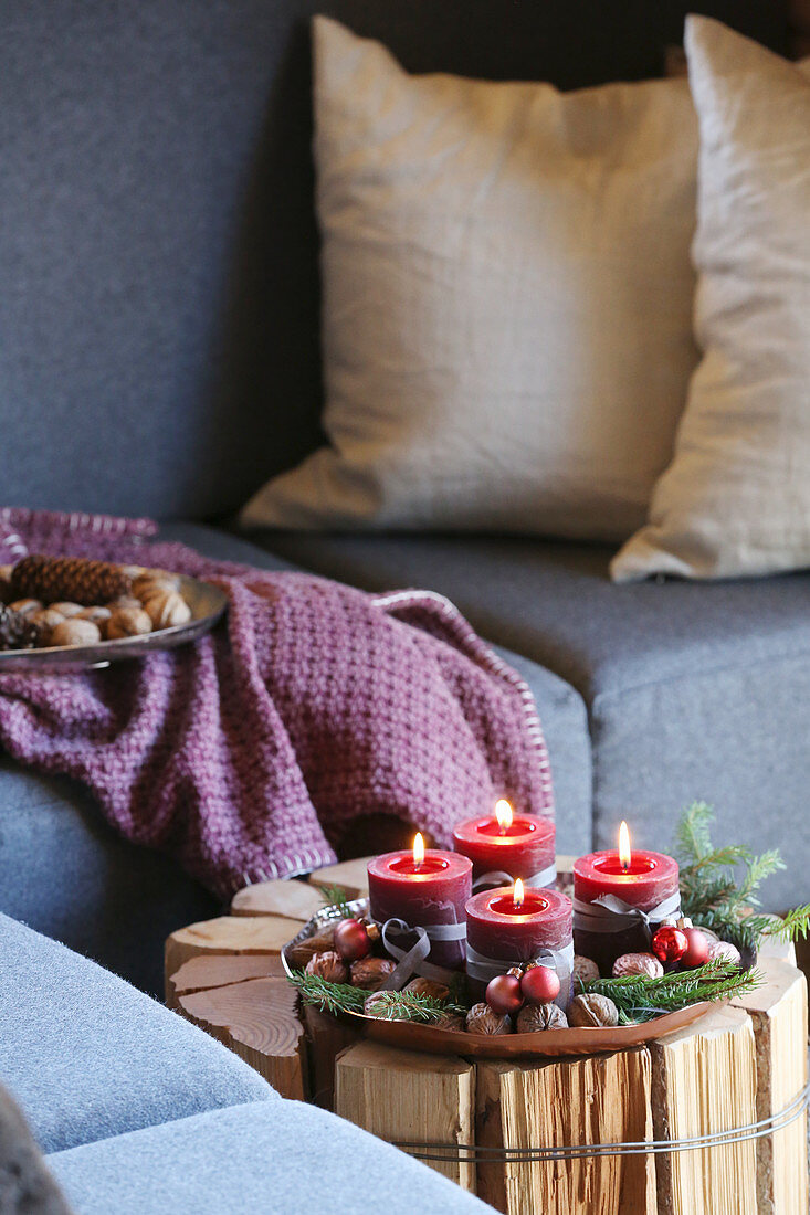 Advent candles in dish on side table handmade from logs