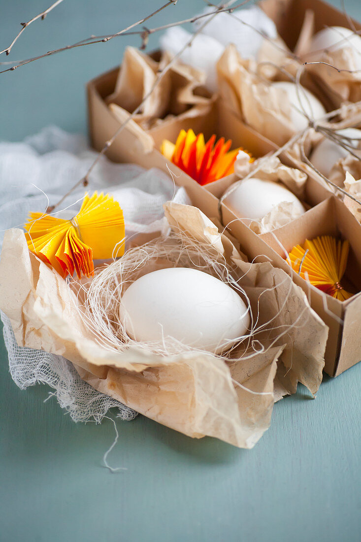 weiße Eier und gelbe Papierrosetten