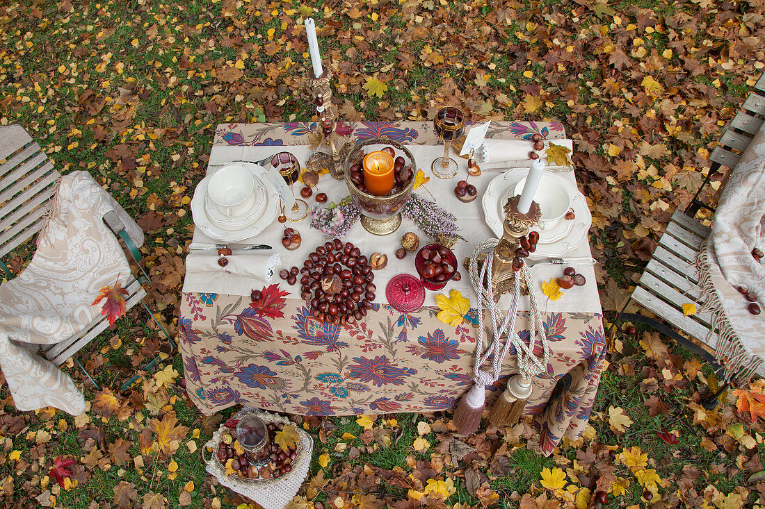 Herbstlich dekorierter Tisch mit zwei Stühlen im Garten