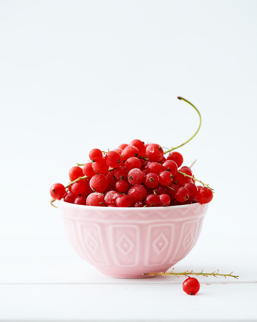 Frozen cranberries in a small ceramic bowl