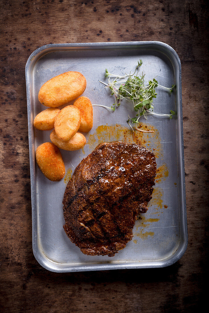 Gegrilltes Ribeye-Steak mit frittierten Kartoffeln (Aufsicht)