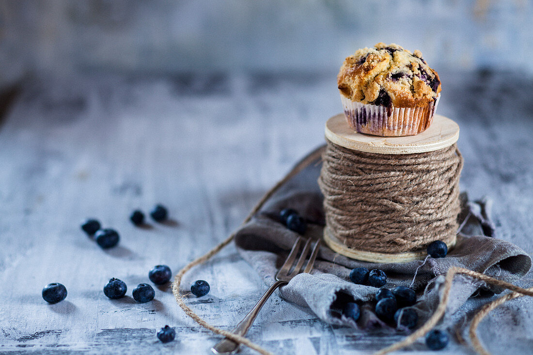 A blueberry muffin on a roll on string